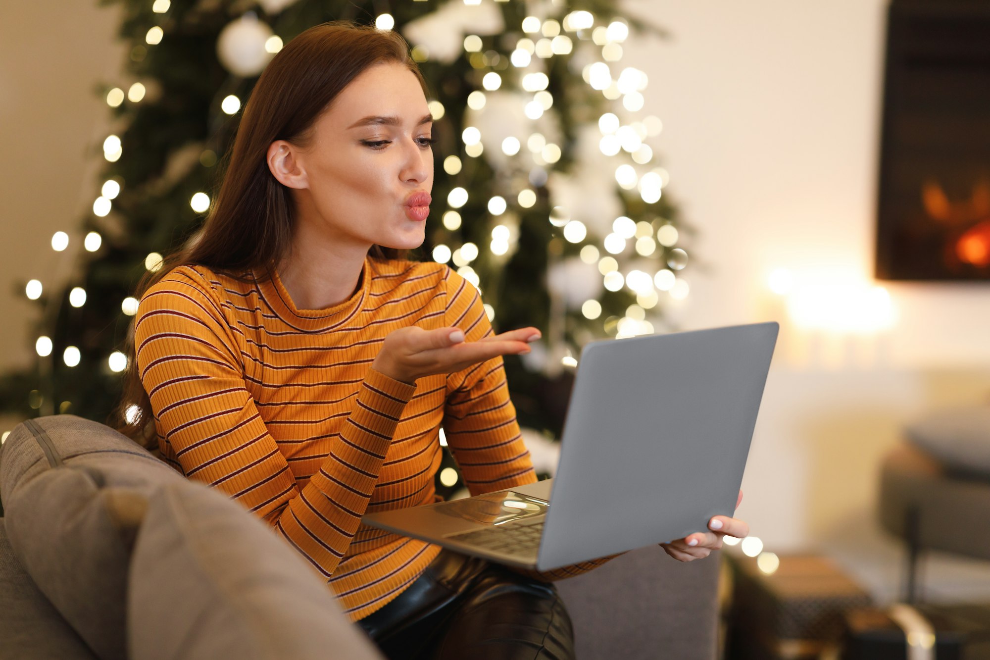 Woman blowing kiss during virtual date on laptop