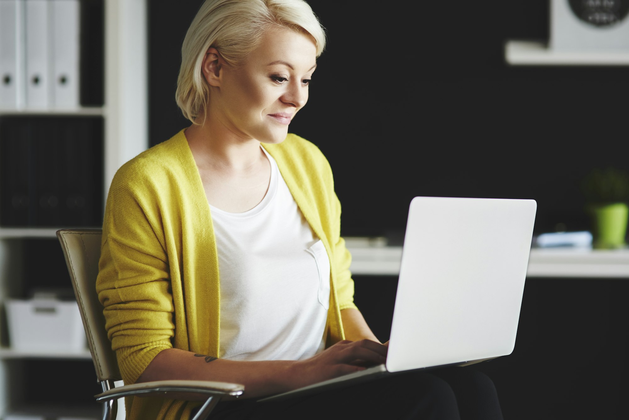 Woman with a laptop on knee chatting